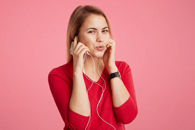 La mujer complacida disfruta de su canción favorita en los auriculares