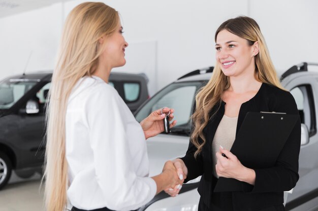 Mujer comprando auto nuevo en concesionario