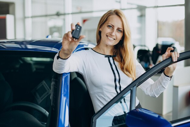 Mujer comprando un coche nuevo en un salón de autos