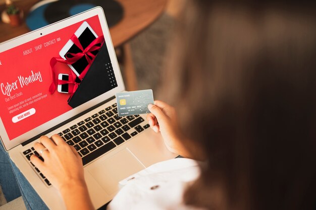 Mujer comprando con tarjeta de crédito sobre la vista del hombro