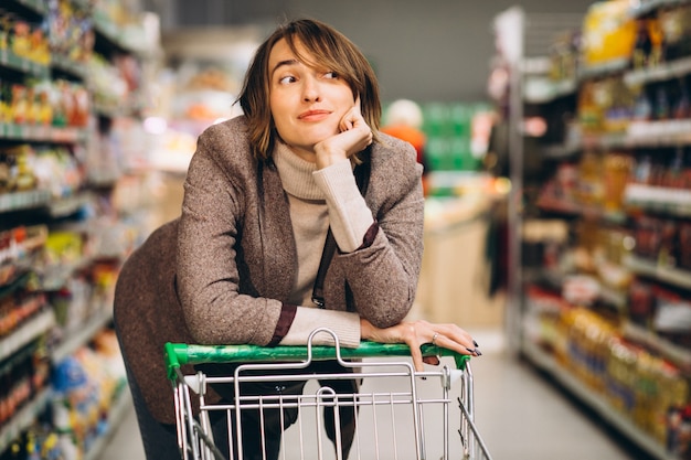 Mujer de compras en la tienda de comestibles