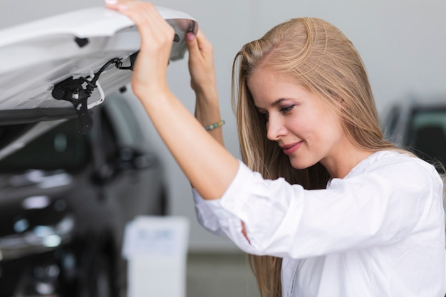 Foto gratuita mujer comprobando el motor de su coche