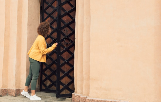 Foto gratuita mujer comprobando una puerta con espacio de copia