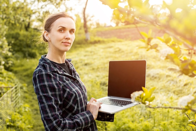 Mujer con una computadora portátil en la granja
