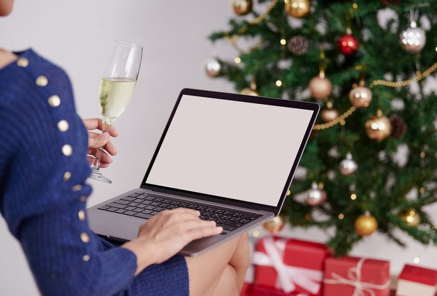 Mujer de computadora portátil de pantalla de maqueta usando videoconferencia fiesta de navidad en línea con amigos