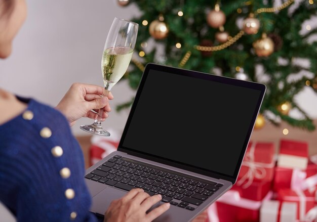 Mujer de computadora portátil de pantalla de maqueta usando videoconferencia fiesta de navidad en línea con amigos