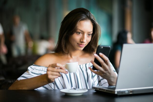 Mujer, con, computadora portátil, trabajando, en, un, café