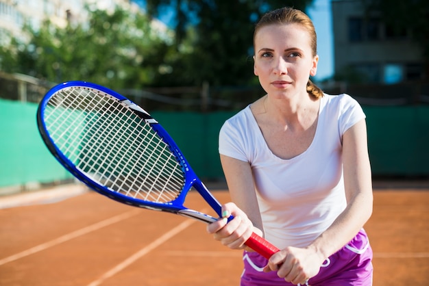Mujer concentrada jugando al tenis