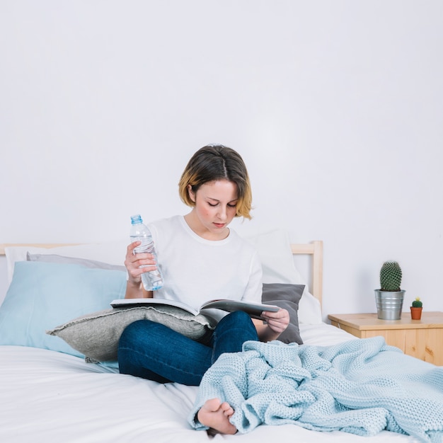 Foto gratuita mujer concentrada con la revista de lectura de agua