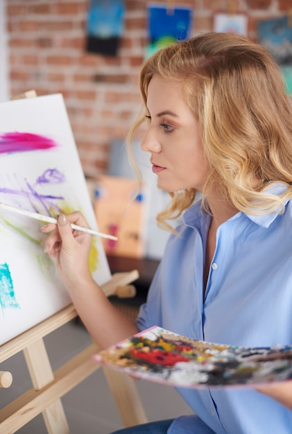 Mujer concentrada trabajando en la pintura