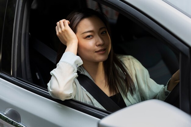 Mujer conductora posando en un coche eléctrico