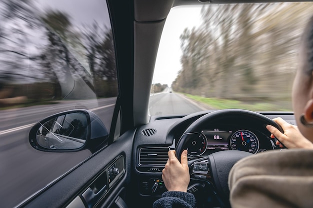 Mujer conductores manos en el volante de un coche