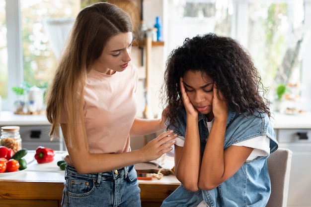 Mujer consolando a su amiga en la cocina