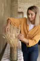 Foto gratuita mujer construyendo su propio arreglo de flores secas