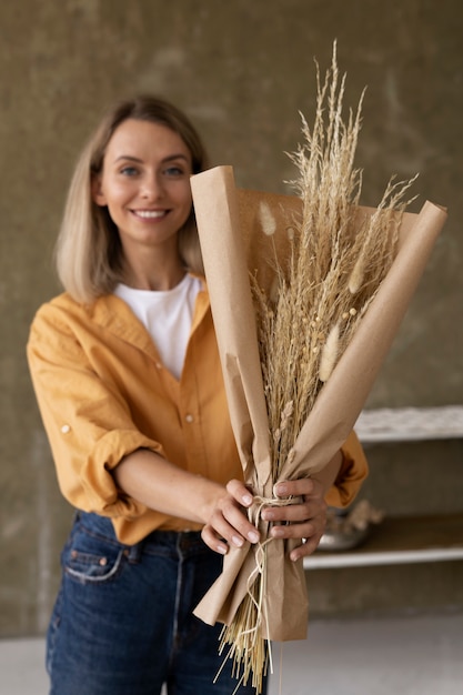 Mujer construyendo su propio arreglo de flores secas