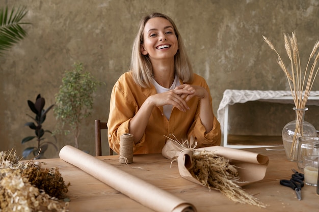 Foto gratuita mujer construyendo su propio arreglo de flores secas