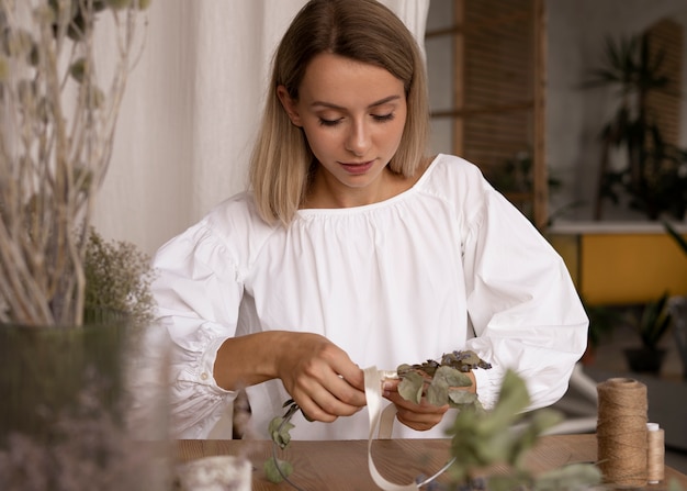 Foto gratuita mujer construyendo su propio arreglo de flores secas