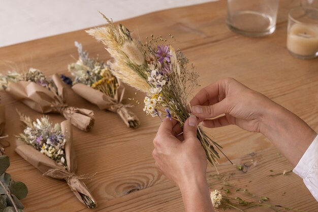 Mujer construyendo su propio arreglo de flores secas