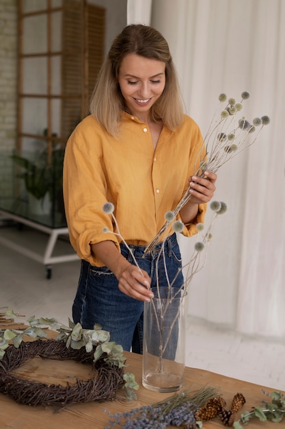 Mujer construyendo su propio arreglo de flores secas