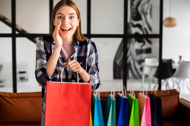 Mujer contando un secreto y sosteniendo una bolsa de papel