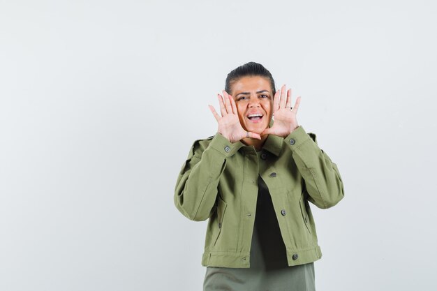 Mujer contando secretos o anunciando algo en chaqueta, camiseta y luciendo optimista.