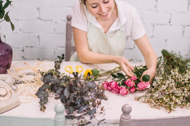 Mujer contenta que crea el ramo floral