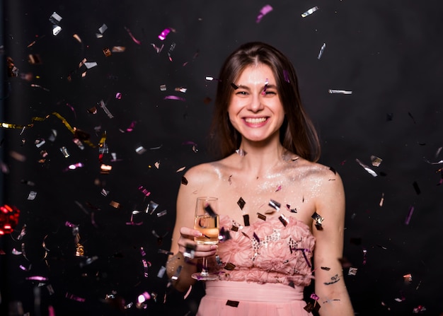 Mujer con copa de champagne bajo lentejuelas