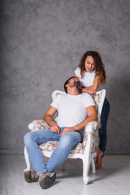 Mujer coqueteando con hombre en sillón