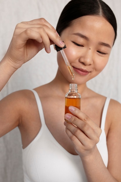 Mujer coreana de tiro medio posando con suero