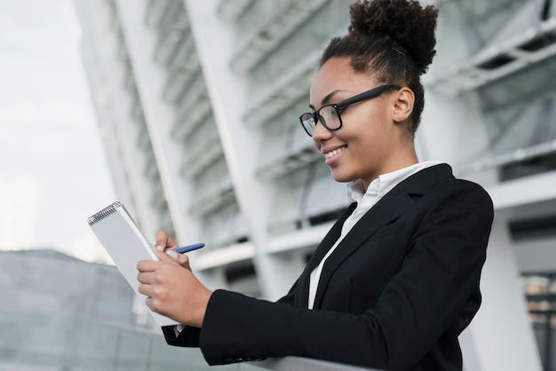 Mujer corporativa escribiendo en cuaderno