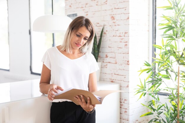 Mujer corporativa leyendo tiro medio