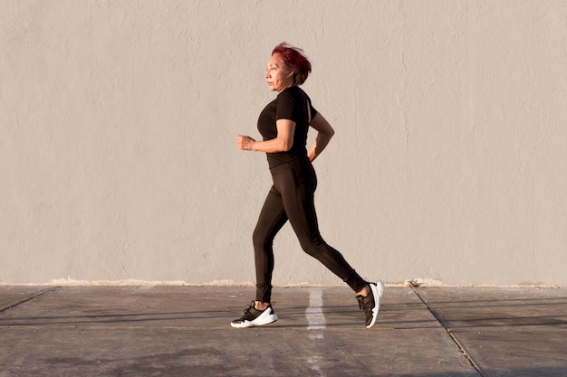 Mujer corriendo al aire libre tiro de vista lateral