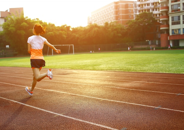 Mujer corriendo en un circuito deportivo