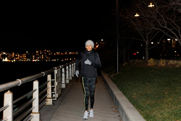 Mujer corriendo de noche en la ciudad