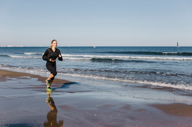 Mujer corriendo en la orilla