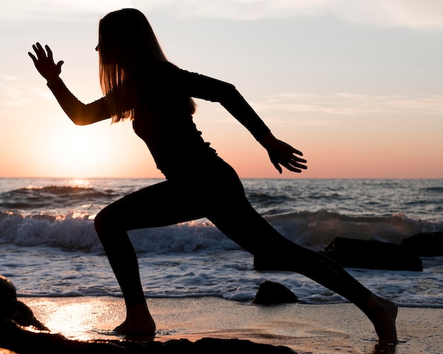 Mujer corriendo en la playa al atardecer