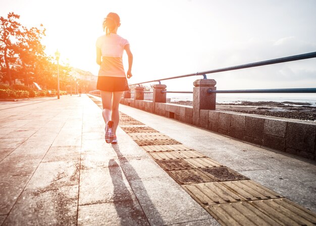 Mujer corriendo hacia el sol