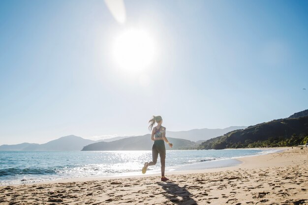 Foto gratuita mujer corriendo sola en la playa