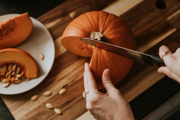 Mujer cortando calabaza para la fotografía de comida de la cena de Acción de Gracias