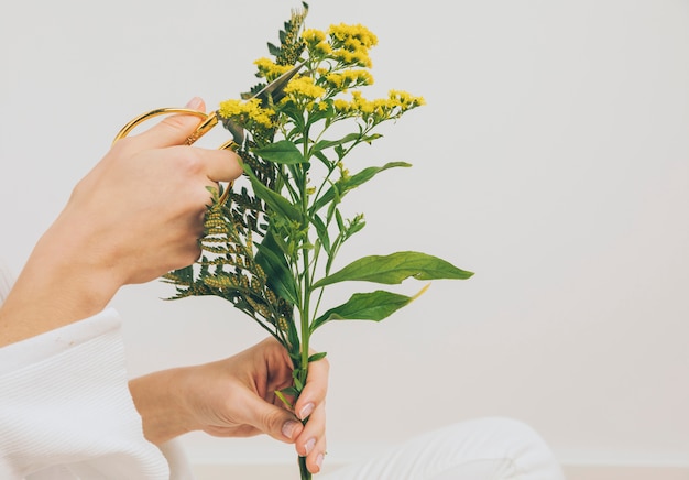 Mujer cortando flores con tijeras