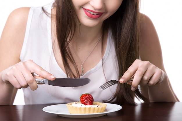 Foto gratuita mujer cortando una fresa con cubiertos