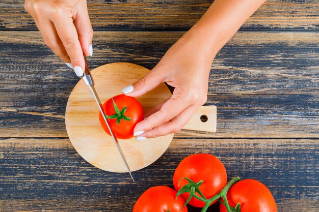 Mujer cortando tomate con cuchillo