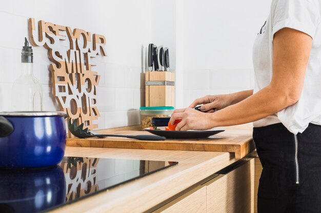 Mujer cortando tomates en la mesa