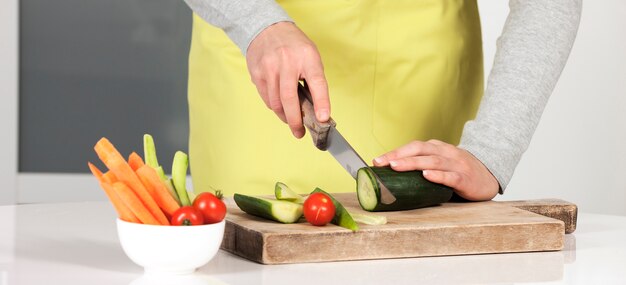 Mujer cortando verduras en la cocina