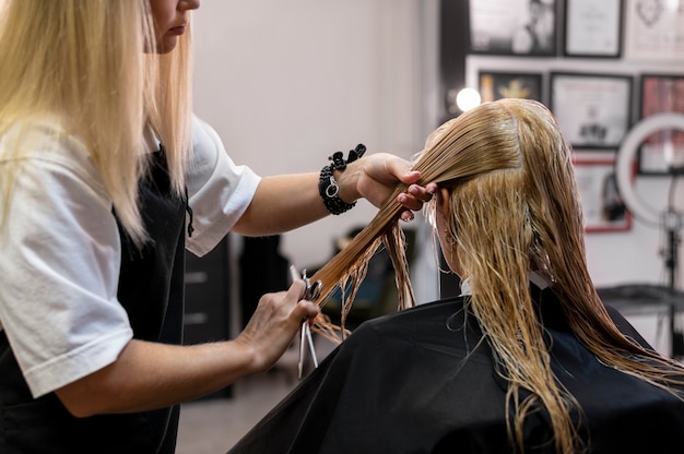 Mujer cortándose el pelo en el salón de belleza