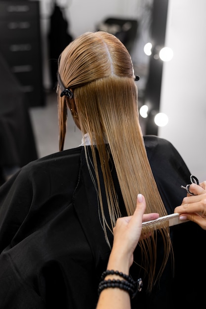 Mujer cortándose el pelo en el salón de belleza