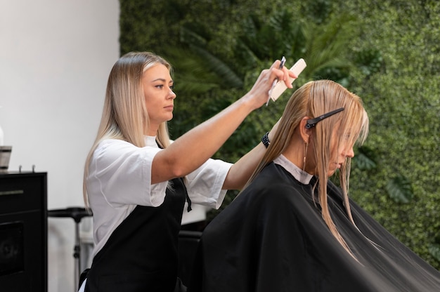 Mujer cortándose el pelo en el salón de belleza