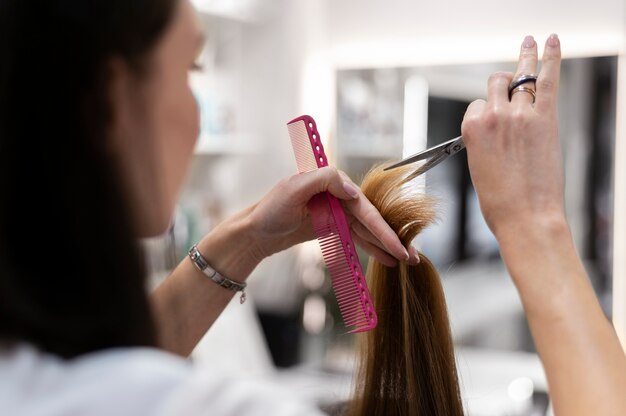 Mujer cortándose el pelo en el salón de belleza