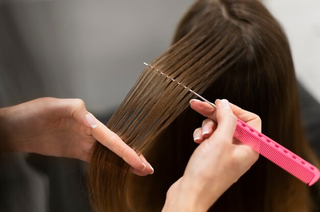 Mujer cortándose el pelo en el salón de belleza