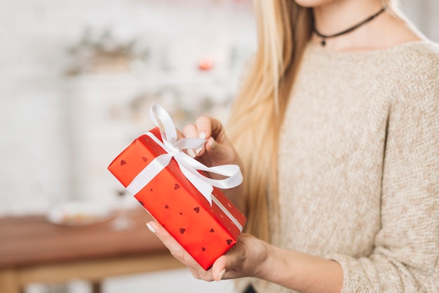 Mujer de la cosecha abriendo caja de regalo roja